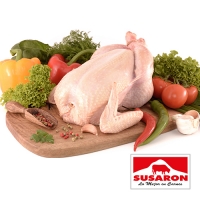 pollo entero con verduras crudas sobre tabla de madera